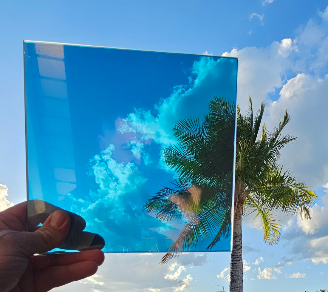 Roll of metallic turquoise blue automotive styling film partially unrolled to reveal its glossy reflective surface and white backing, displayed against a solid black background. Vibrant turquoise blue vinyl wrap with a metallic finish for custom vehicle styling.